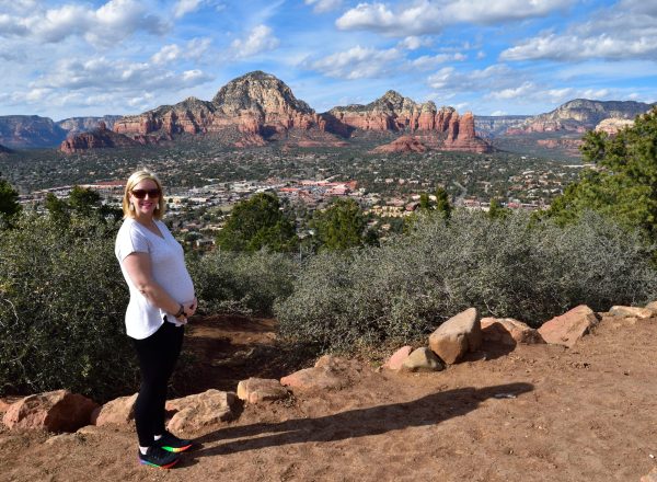 pregnant woman stands outside on mountain