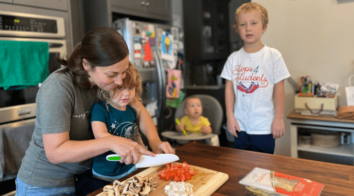 woman with kids in kitchen preparing dinner