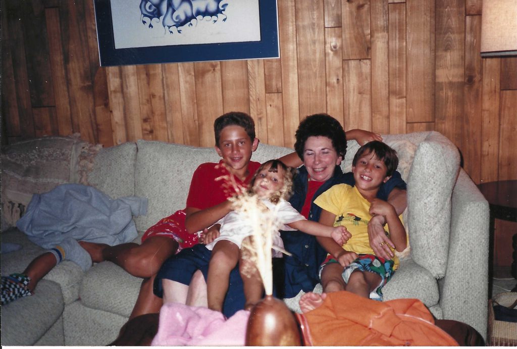 children with grandmother sitting on couch