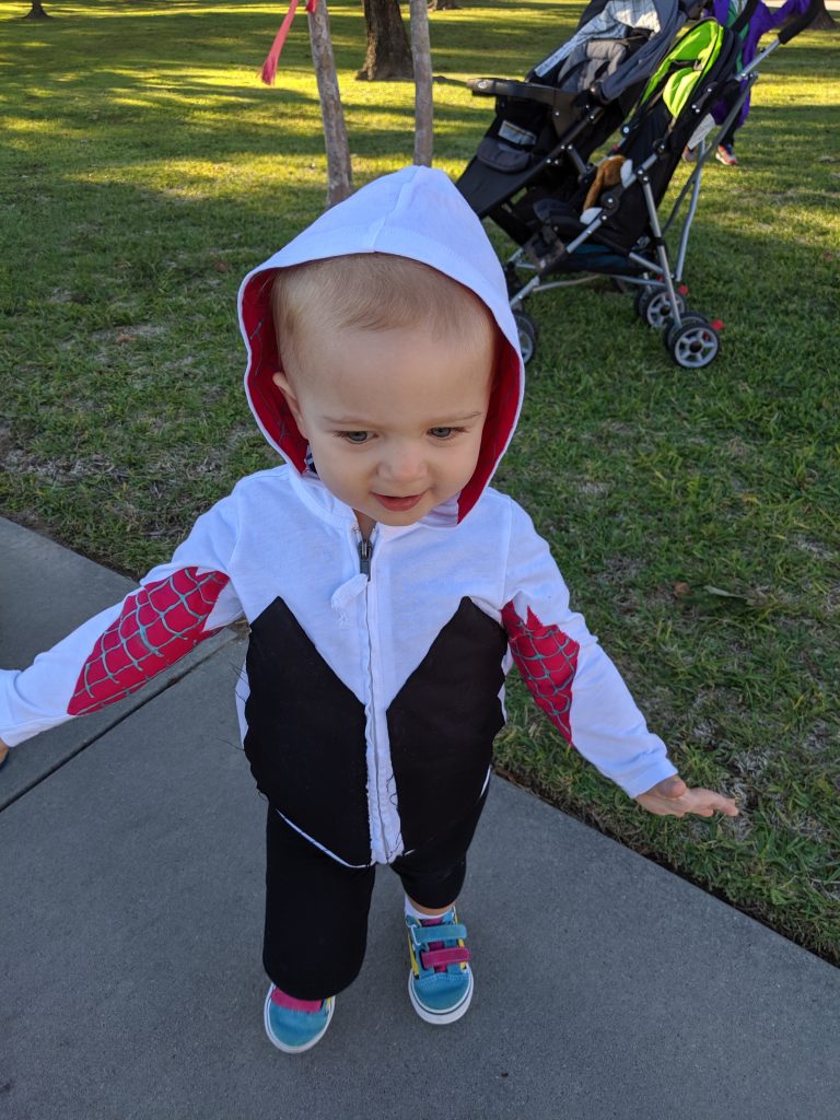 toddler in Halloween costume on sidewalk