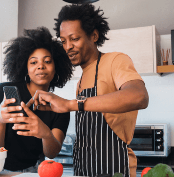 couple in kitchen looking at phone