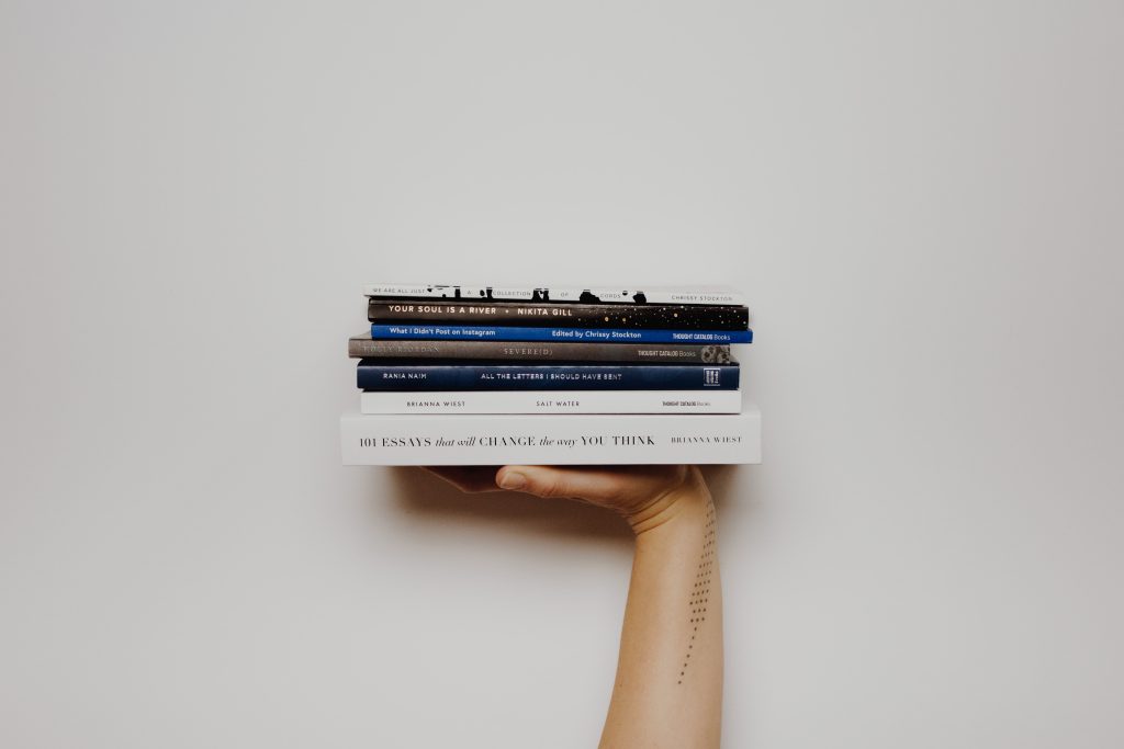 hand holding stack of books