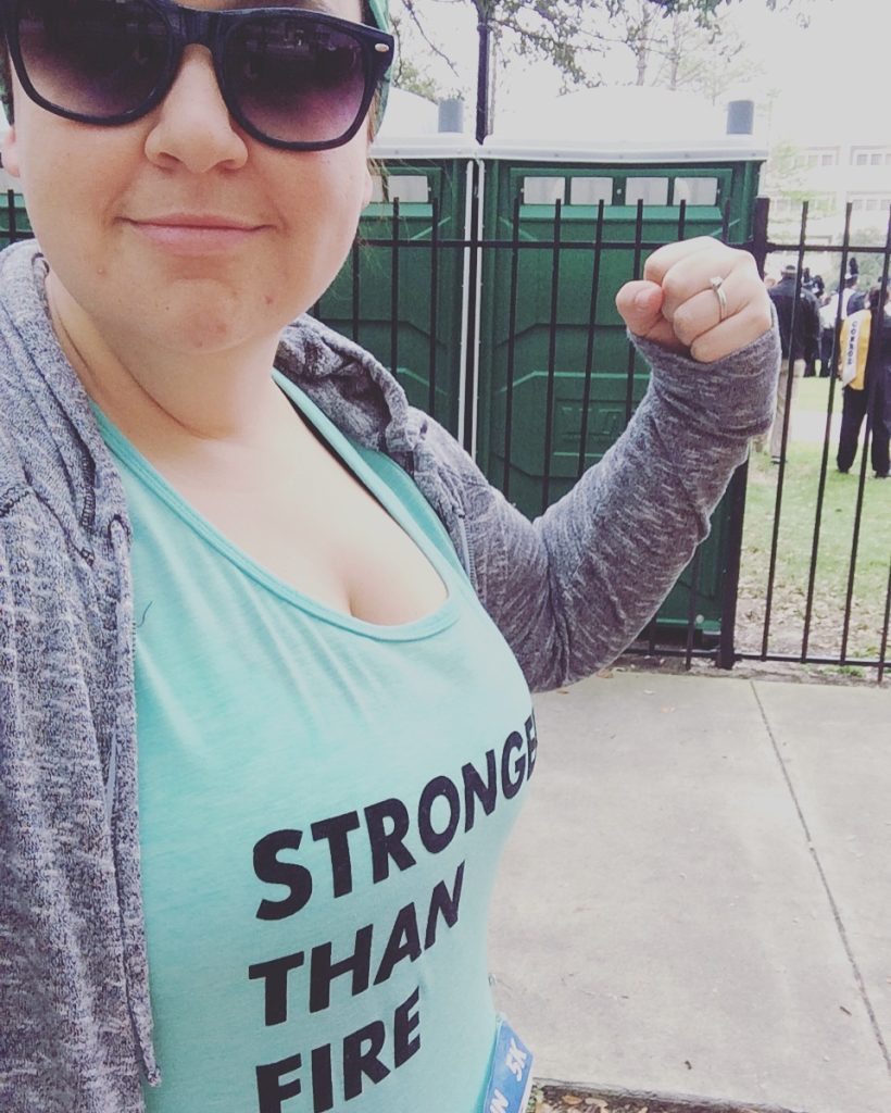 woman wearing a shirt that says "Stronger than Fire"