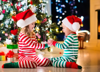 kids in Christmas pajamas in front of tree