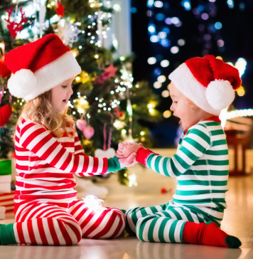 kids in Christmas pajamas in front of tree