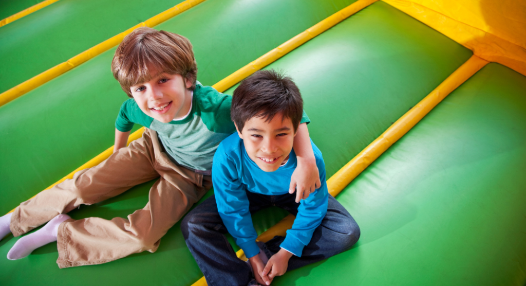 two boys sitting in bounce house