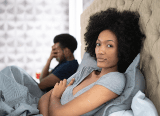 couple in bed- woman looking away and man frustrated
