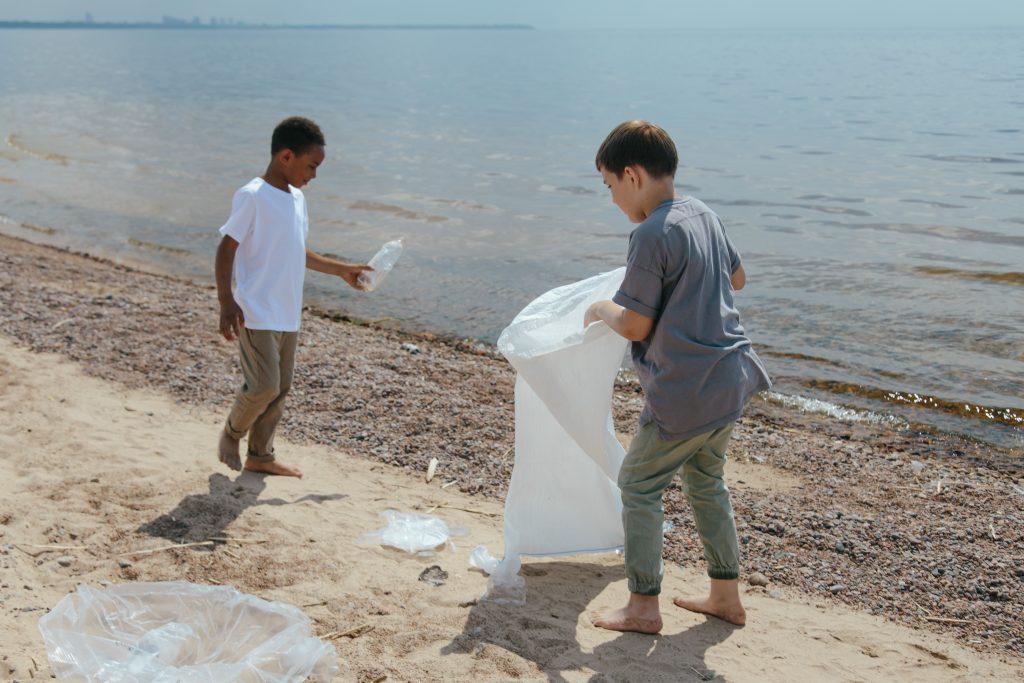 kids cleaning up trash on the beach