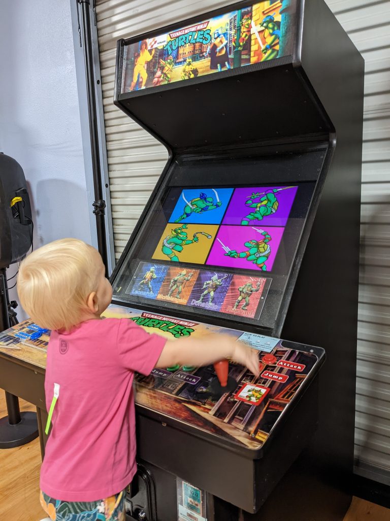 toddler plays arcade game at Kanga's Indoor Playground