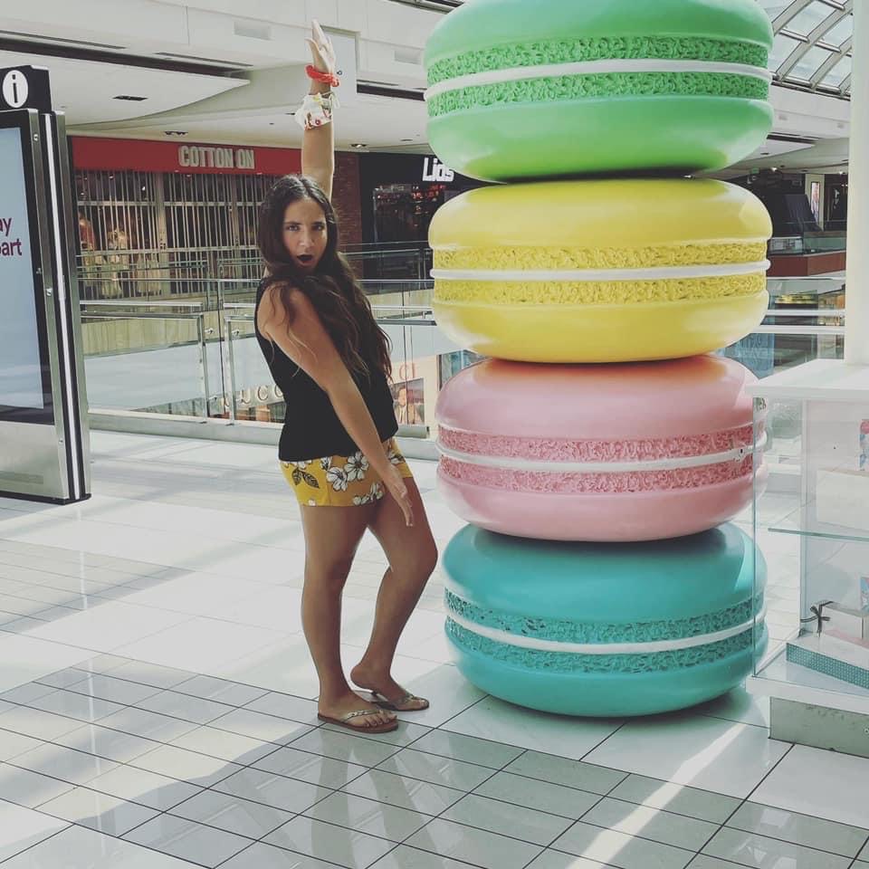 teen poses with macaroon statue at the Houston Galleria