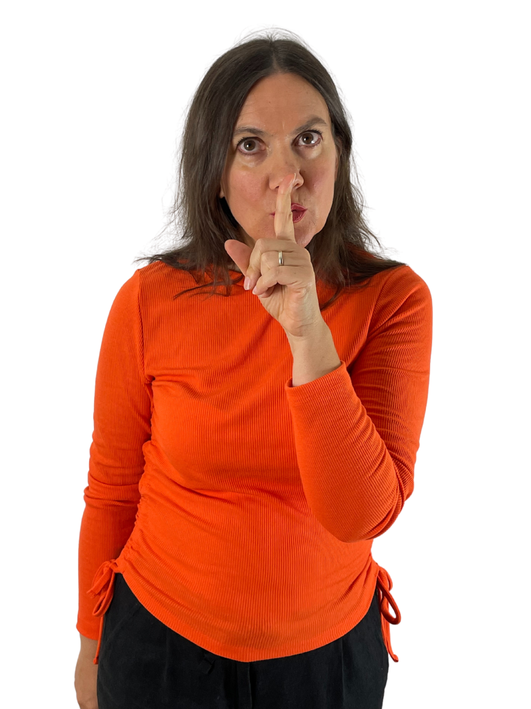 woman with finger to her lips, implying "Shh"