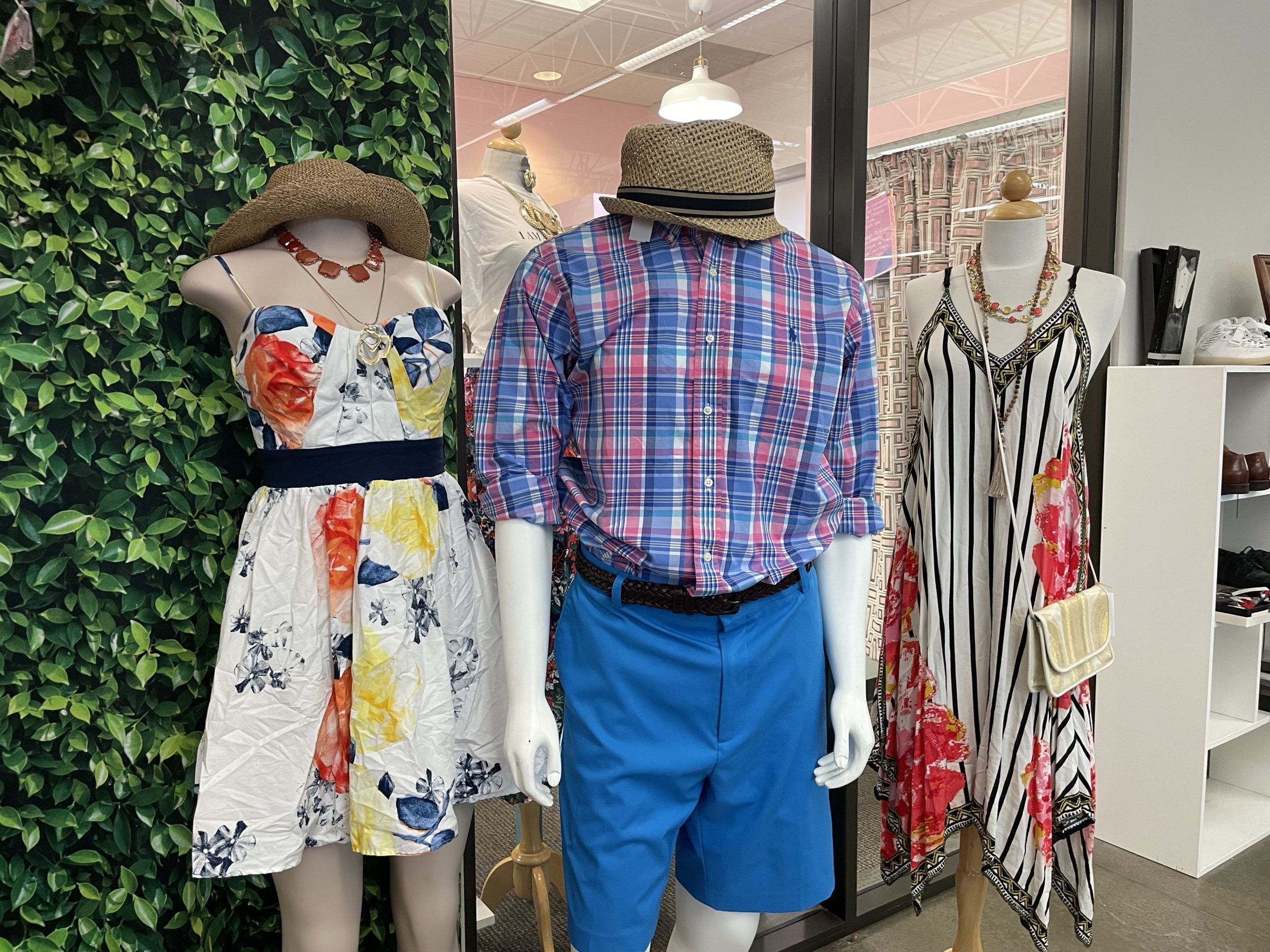 display of 2 women's and one man's summer outfit on mannequins
